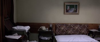 Movie still from “4 Months, 3 Weeks and 2 Days” (2007), directed by Cristian Mungiu – A bed room with a bed and a telephone on a nightstand; Wide shot, High angle
