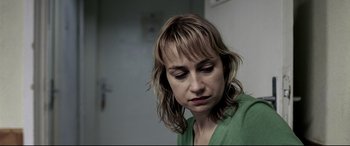 Movie still from “4 Months, 3 Weeks and 2 Days” (2007), directed by Cristian Mungiu – A person wearing a green shirt; Close Up shot, Over the shoulder angle