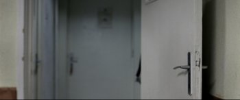 Movie still from “4 Months, 3 Weeks and 2 Days” (2007), directed by Cristian Mungiu – A blurry image of a door and a wall in a room; Extreme Close Up shot, Over the shoulder angle