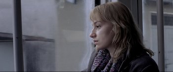 Movie still from “4 Months, 3 Weeks and 2 Days” (2007), directed by Cristian Mungiu – A woman sitting on a train looking out the window; Close Up shot, Low angle