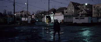 Movie still from “4 Months, 3 Weeks and 2 Days” (2007), directed by Cristian Mungiu – A person standing in the middle of a street at night; Wide shot, High angle