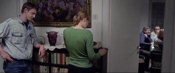Movie still from “4 Months, 3 Weeks and 2 Days” (2007), directed by Cristian Mungiu – A woman in a green shirt standing in front of a bookshelf; Medium shot, High angle