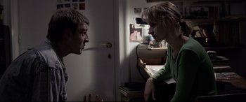 Movie still from “4 Months, 3 Weeks and 2 Days” (2007), directed by Cristian Mungiu – A man and a woman talking to each other in a living room; Medium shot, Over the shoulder angle