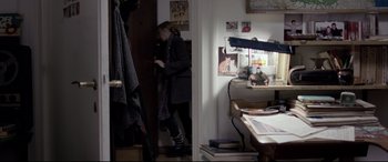 Movie still from “4 Months, 3 Weeks and 2 Days” (2007), directed by Cristian Mungiu – A woman standing next to a desk in a room; Medium shot, Over the shoulder angle