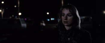 Movie still from “4 Months, 3 Weeks and 2 Days” (2007), directed by Cristian Mungiu – A woman is standing in the dark looking at the camera; Close Up shot, Over the shoulder angle