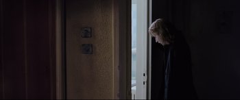 Movie still from “4 Months, 3 Weeks and 2 Days” (2007), directed by Cristian Mungiu – A woman standing at the door of a house; Medium shot, Over the shoulder angle