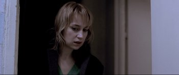 Movie still from “4 Months, 3 Weeks and 2 Days” (2007), directed by Cristian Mungiu – A woman with blonde hair and a green shirt looking down; Close Up shot, Over the shoulder angle
