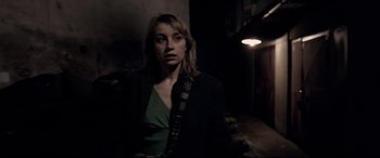 Movie still from “4 Months, 3 Weeks and 2 Days” (2007), directed by Cristian Mungiu – A woman in a black jacket standing in a dark room; Medium shot, Low angle