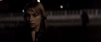 Movie still from “4 Months, 3 Weeks and 2 Days” (2007), directed by Cristian Mungiu – A woman is standing in the dark looking at the camera; Close Up shot, Over the shoulder angle