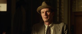 Movie still from “42” (2013), directed by Brian Helgeland – A man wearing a suit and hat in a dimly lit room; Close Up shot, Low angle