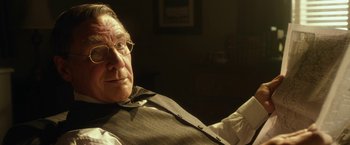 Movie still from “42” (2013), directed by Brian Helgeland – An older man sitting in a chair with his arms crossed; Close Up shot, Over the shoulder angle