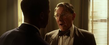 Movie still from “42” (2013), directed by Brian Helgeland – An older man wearing a suit and bow tie talking to a younger man; Close Up shot, Over the shoulder angle