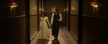 Movie still from “42” (2013), directed by Brian Helgeland – A man and a woman walking down a hallway holding hands; Wide shot, Low angle