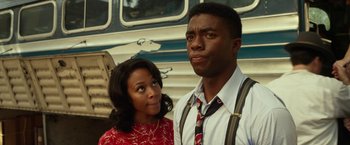 Movie still from “42” (2013), directed by Brian Helgeland – A man and a woman standing next to each other in front of a bus; Close Up shot, Low angle