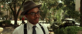 Movie still from “42” (2013), directed by Brian Helgeland – A man wearing a hat , glasses , and a tie; Close Up shot, Over the shoulder angle