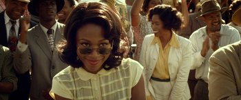 Movie still from “42” (2013), directed by Brian Helgeland – A young woman wearing sunglasses and a white shirt; Close Up shot, Over the shoulder angle