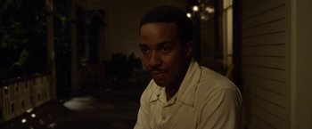 Movie still from “42” (2013), directed by Brian Helgeland – A man in a yellow shirt is smiling for the camera; Close Up shot, Over the shoulder angle