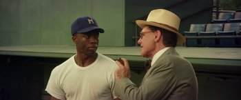 Movie still from “42” (2013), directed by Brian Helgeland – A man wearing a hat talking to another man wearing a hat; Medium shot, Over the shoulder angle