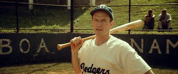 Movie still from “42” (2013), directed by Brian Helgeland – An older man holding a baseball bat in a baseball uniform; Medium shot, Over the shoulder angle
