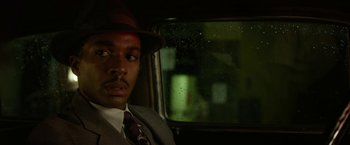 Movie still from “42” (2013), directed by Brian Helgeland – A man wearing a suit and hat sitting in a car; Close Up shot, Over the shoulder angle