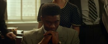Movie still from “42” (2013), directed by Brian Helgeland – A man in a gray suit and a woman in a polka dot dress; Close Up shot, Over the shoulder angle