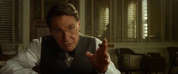 Movie still from “42” (2013), directed by Brian Helgeland – An older man holding a cigar in a room; Close Up shot, Over the shoulder angle