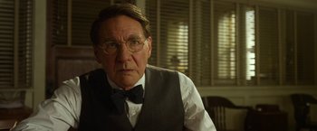 Movie still from “42” (2013), directed by Brian Helgeland – An older man wearing glasses and a bow tie; Close Up shot, Over the shoulder angle
