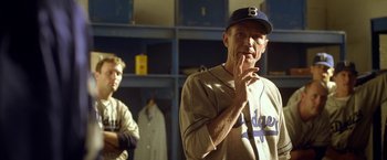Movie still from “42” (2013), directed by Brian Helgeland – A man in a baseball uniform standing next to another man; Medium shot, Over the shoulder angle
