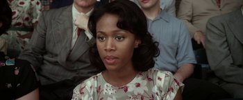 Movie still from “42” (2013), directed by Brian Helgeland – A young woman in a floral dress looks at the camera; Close Up shot, Over the shoulder angle