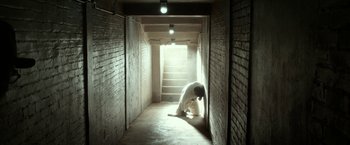 Movie still from “42” (2013), directed by Brian Helgeland – A man kneeling down in the middle of a hallway; Wide shot, Low angle