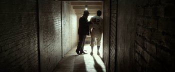 Movie still from “42” (2013), directed by Brian Helgeland – A man and a baseball player in a tunnel; Wide shot, Low angle