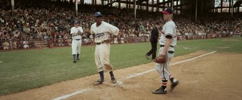 Movie still from “42” (2013), directed by Brian Helgeland – A baseball player standing next to home base; Wide shot, Over the shoulder angle