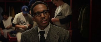 Movie still from “42” (2013), directed by Brian Helgeland – A man wearing a suit and tie and glasses; Close Up shot, Over the shoulder angle