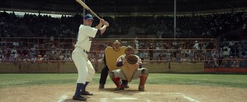 Movie still from “42” (2013), directed by Brian Helgeland – A baseball player swinging a bat at a game; Wide shot, High angle