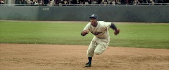 Movie still from “42” (2013), directed by Brian Helgeland – A baseball player running on a baseball field; Medium shot, High angle