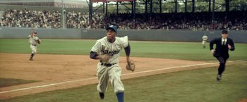 Movie still from “42” (2013), directed by Brian Helgeland – A baseball player throwing a ball on a baseball field; Wide shot, High angle