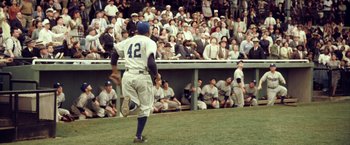 Movie still from “42” (2013), directed by Brian Helgeland – A baseball player walking across a field with a crowd watching; Wide shot, High angle