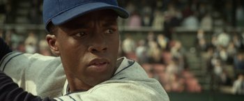 Movie still from “42” (2013), directed by Brian Helgeland – A baseball player wearing a hat; Close Up shot, Over the shoulder angle
