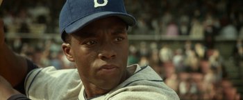 Movie still from “42” (2013), directed by Brian Helgeland – A person wearing a baseball uniform; Close Up shot, Over the shoulder angle