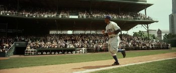 Movie still from “42” (2013), directed by Brian Helgeland – A baseball player running on a baseball field; Wide shot, High angle