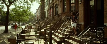 Movie still from “42” (2013), directed by Brian Helgeland – A woman sitting on the steps of an old building; Extreme Wide shot, Low angle