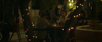 Movie still from “47 Meters Down” (2017), directed by Johannes Roberts – A group of people sitting around a table at a restaurant; Medium shot, Over the shoulder angle