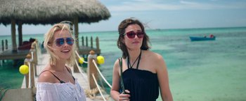 Movie still from “47 Meters Down” (2017), directed by Johannes Roberts – A woman in a black dress and sunglasses; Medium shot, Over the shoulder angle