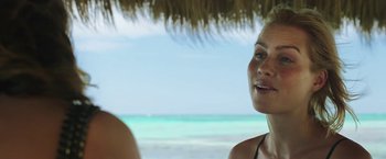 Movie still from “47 Meters Down” (2017), directed by Johannes Roberts – A woman standing next to a man under a straw umbrella; Close Up shot, Over the shoulder angle