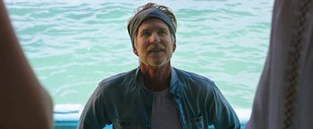 Movie still from “47 Meters Down” (2017), directed by Johannes Roberts – A man with a beard wearing a blue shirt and a headband; Close Up shot, Over the shoulder angle