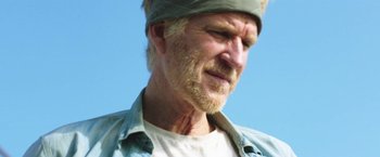 Movie still from “47 Meters Down” (2017), directed by Johannes Roberts – An older man with a beard and a headband; Close Up shot, Low angle
