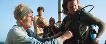 Movie still from “47 Meters Down” (2017), directed by Johannes Roberts – A group of people standing next to each other on a street; Medium shot, Over the shoulder angle