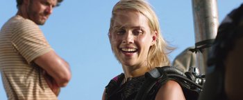 Movie still from “47 Meters Down” (2017), directed by Johannes Roberts – A woman smiles while holding a microphone in her hand; Close Up shot, Over the shoulder angle