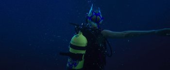 Movie still from “47 Meters Down” (2017), directed by Johannes Roberts – A person in a scuba mask holds onto a scuba tank; Medium shot, High angle