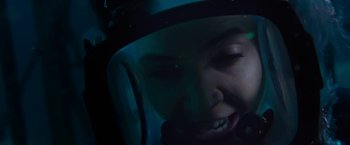 Movie still from “47 Meters Down” (2017), directed by Johannes Roberts – A person wearing a helmet in a dark room; Close Up shot, Overhead angle